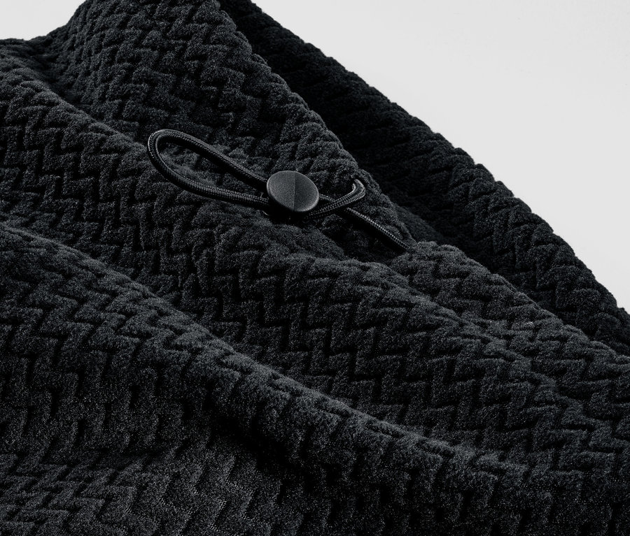 Detailansicht eines schwarzen Fleecekragens mit Textur und Kordelzug.