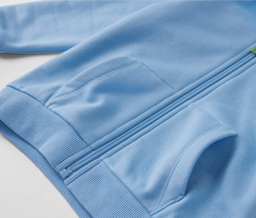 Nahaufnahme einer hellblauen Kinder-Sweatjacke mit angerauter Innenseite, Reißverschluss und Taschen.