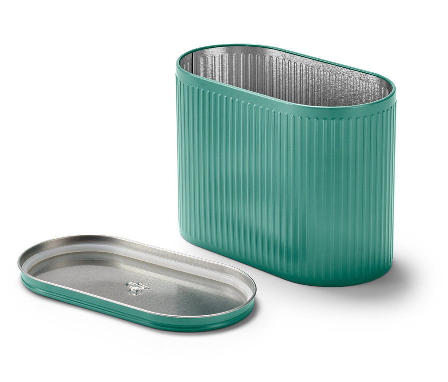 Offene grüne Dose mit Deckel daneben.