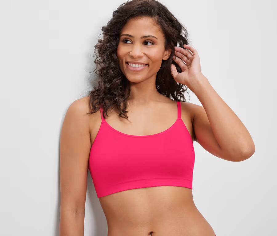 Frau lächelt und trägt ein Seamless-Bustier mit Spitze, fuchsia.