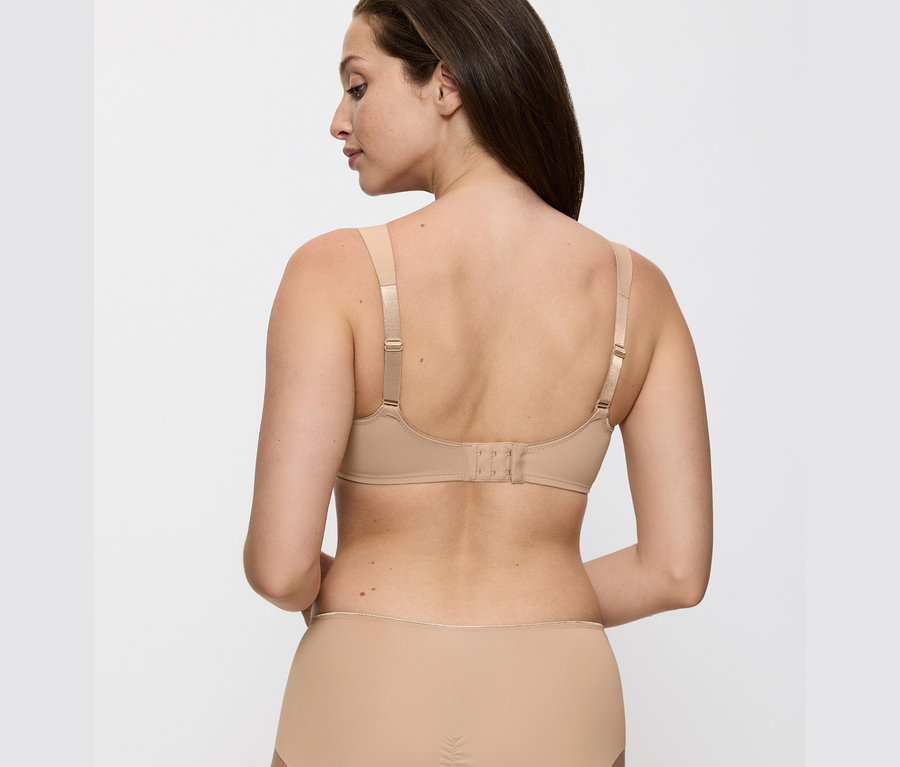 Rückansicht einer Frau, die einen hautfarbenen Triumph Essential »Minimizer W X« BH trägt.