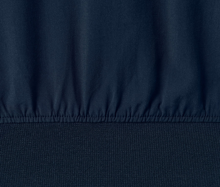 Detailansicht einer dunkelblauen Bluse mit Rippbündchen.