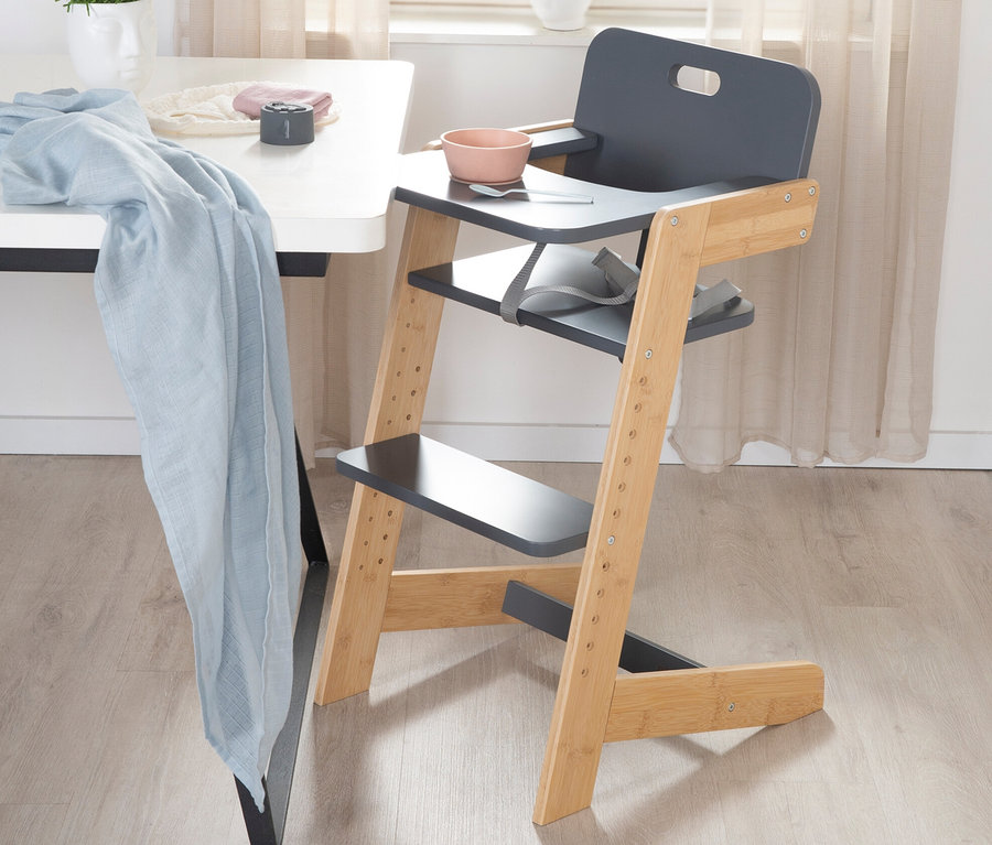Ein anthrazitfarbener roba Babyhochstuhl steht neben einem Tisch.
