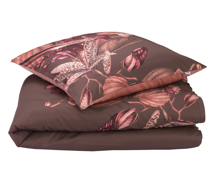 Braune Bettwäsche mit Blumenmuster und Kissen obenauf.