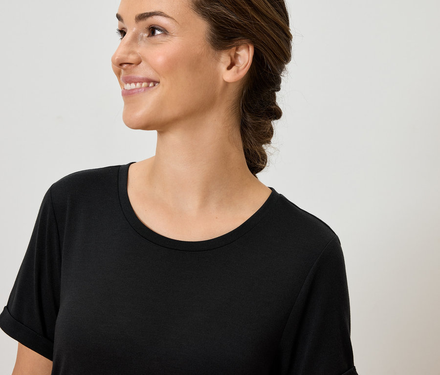 Porträt einer lächelnden Frau in einem schwarzen T-Shirt.