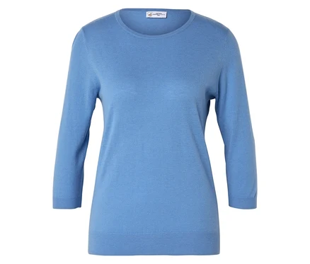 Ein hellblauer Pullover mit Dreiviertelärmeln liegt auf einer weißen Oberfläche.