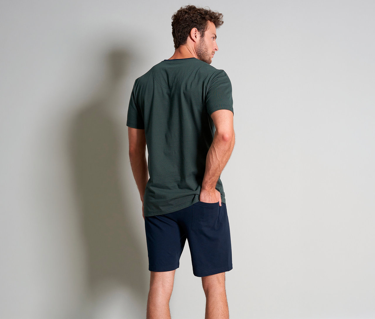 Mann von hinten in grünem Tom Tailor Shorty-Pyjama-Set »Nevada«, wobei eine Hand in der Hosentasche steckt.