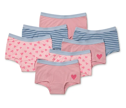 Sieben Mädchenslips in verschiedenen Designs, darunter rosa mit Herzen und blau gestreift.