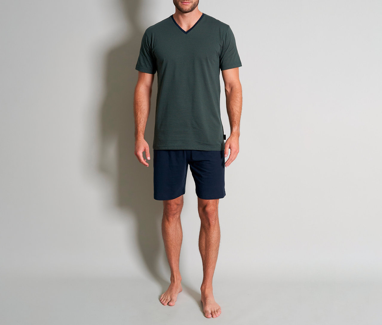 Mann in grünem Tom Tailor Shorty-Pyjama-Set »Nevada«, bestehend aus T-Shirt und kurzer, blauer Hose.