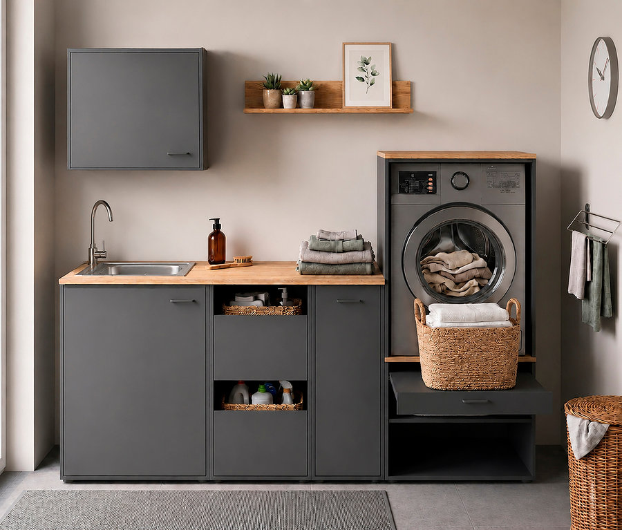 Waschküche mit anthrazitfarbenem Waschmaschinenumbau »Solea U670« mit Holzplatte, Spüle und Hängeschrank. Die Waschmaschine enthält Wäsche, ein Korb mit Handtüchern steht auf einem Auszug.