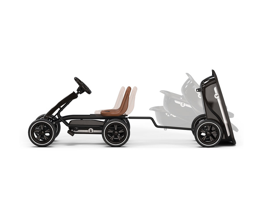 Schwarzes Go-Kart mit schwarzen Rädern mit weißen Felgen und zwei braunen Sitzen, wobei der hintere in mehreren verstellbaren Positionen gezeigt wird, zieht einen schwarzen Anhänger mit mehreren verstellbaren Konfigurationen, auf weißem Hintergrund.