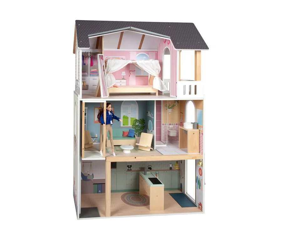 Puppe steht im small foot Puppenhaus »Traumvilla XL«.