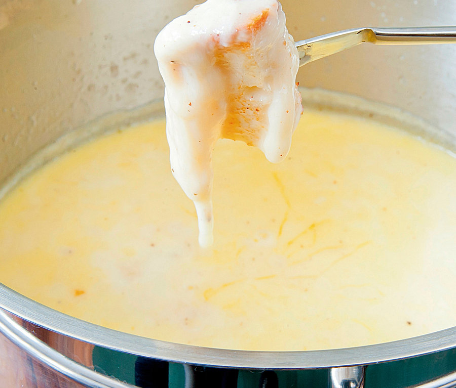 Brotstück wird in CASO Induktions-Fondue getunkt.