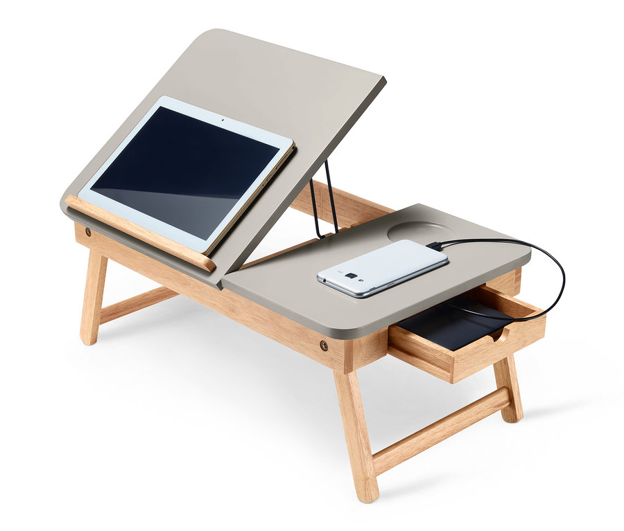 Auf einem Betttisch liegen ein Tablet und ein Handy.