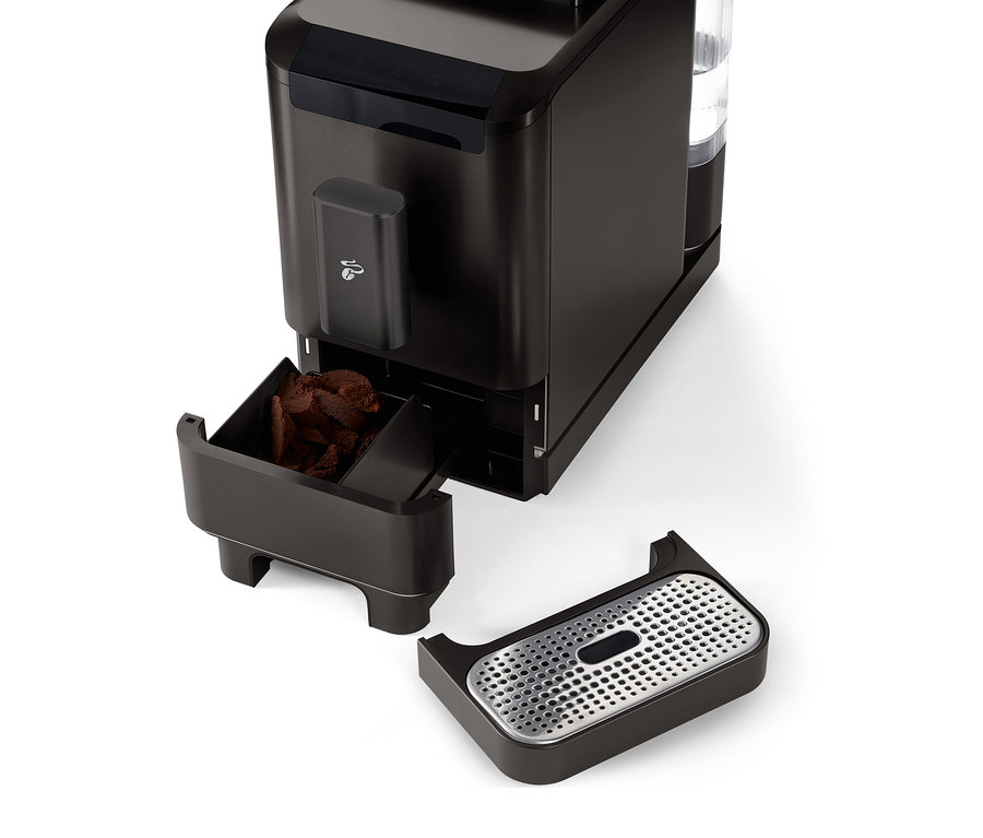 Detailaufnahme des »Esperto2 Caffè« Kaffeevollautomaten in Granite Black mit herausgezogenem Kaffeesatzbehälter und Abtropfschale.