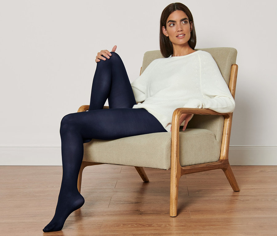 Frau sitzt im Sessel und trägt 2 Paar Feinstrumpfhosen.
