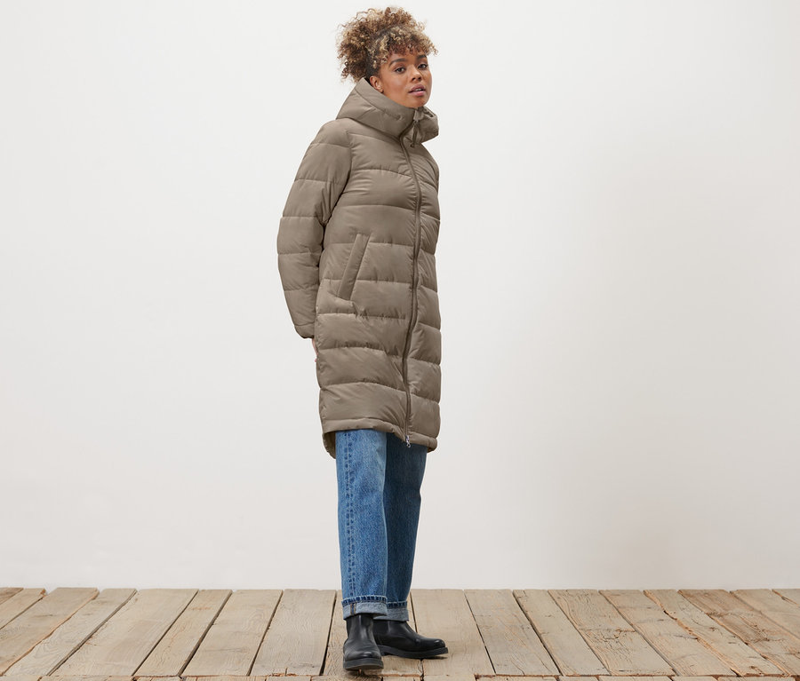 Frau posiert in Steppmantel, taupe.