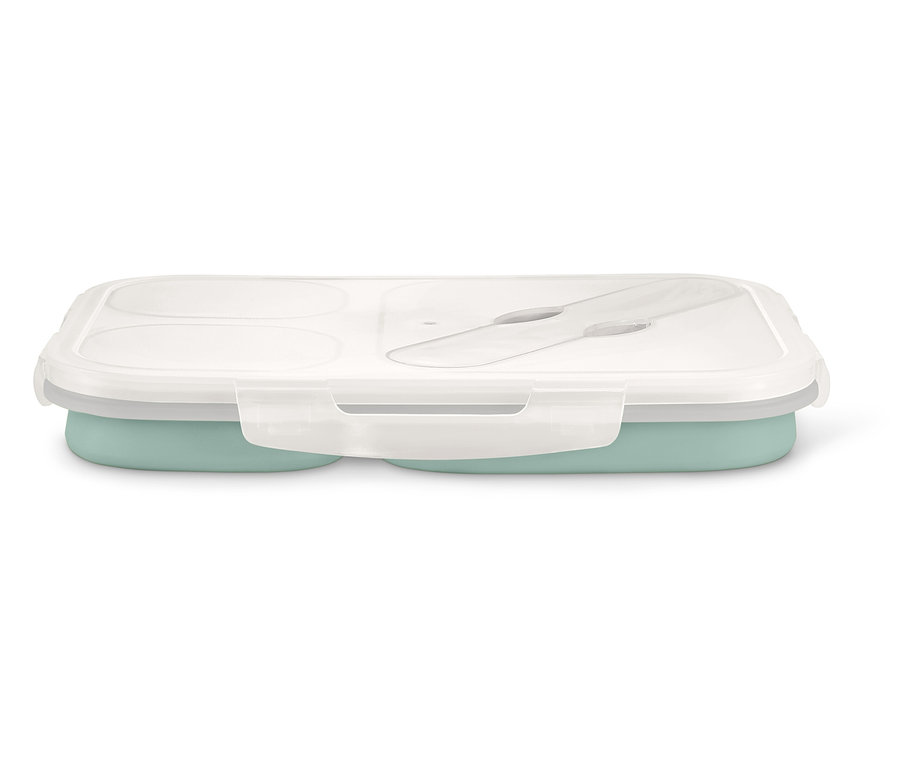 Eine geschlossene Lunchbox mit transparentem Deckel und Besteck innen, der untere Teil ist hellgrün.