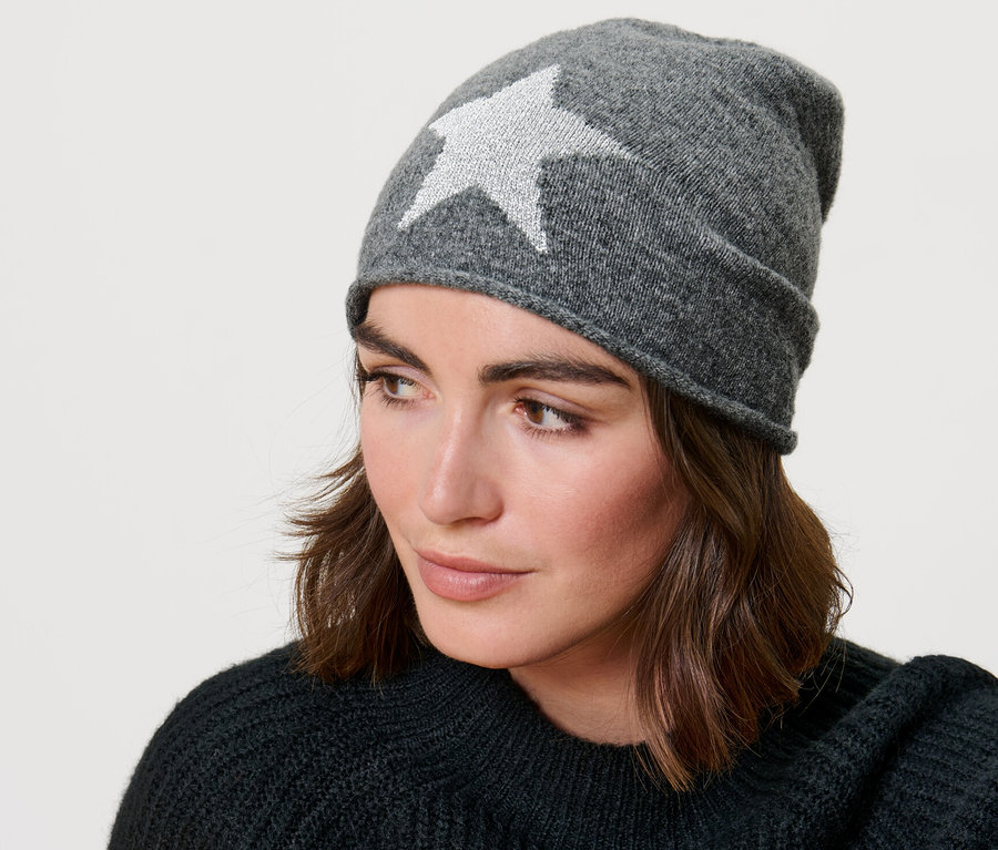 Frau trägt eine Feinstrick-Beanie mit Glitzer-Stern.