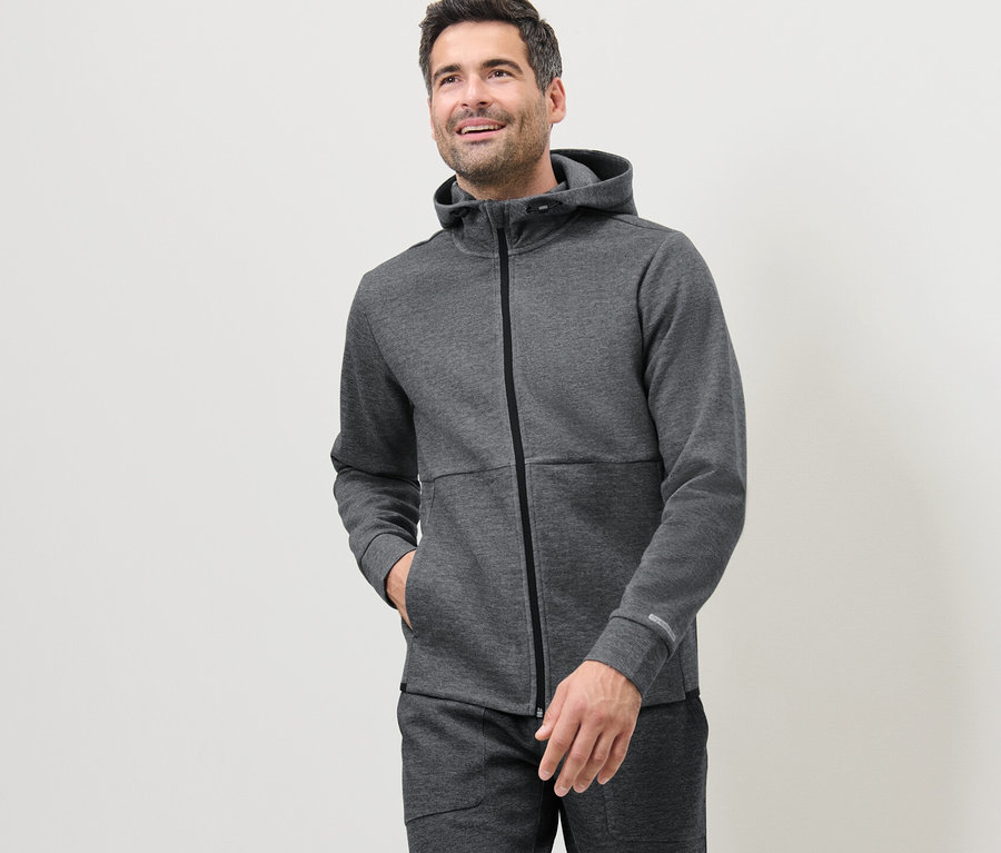 Mann trägt eine graue Funktionssweatjacke.