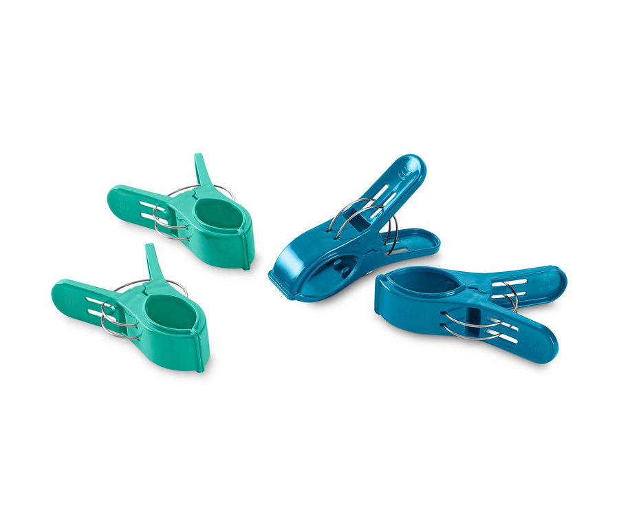 Vier Handtuchclips: zwei grüne und zwei blaue.