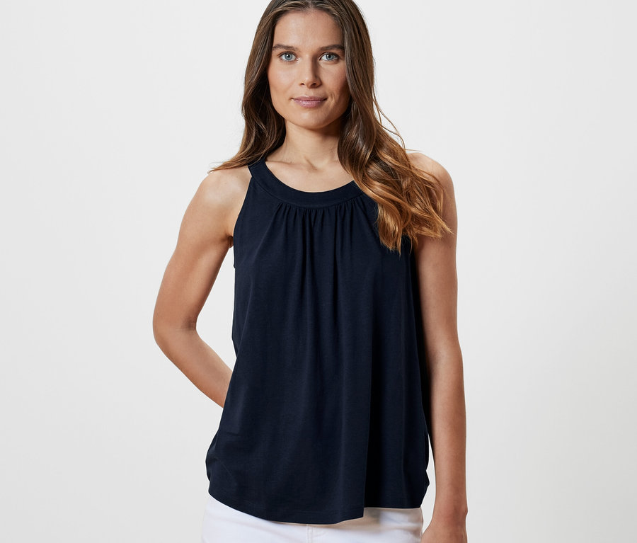Frau posiert in marineblauem Top.