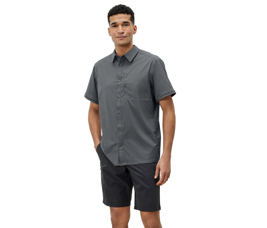 Mann posiert in grauem Outdoorhemd und schwarzen Shorts.