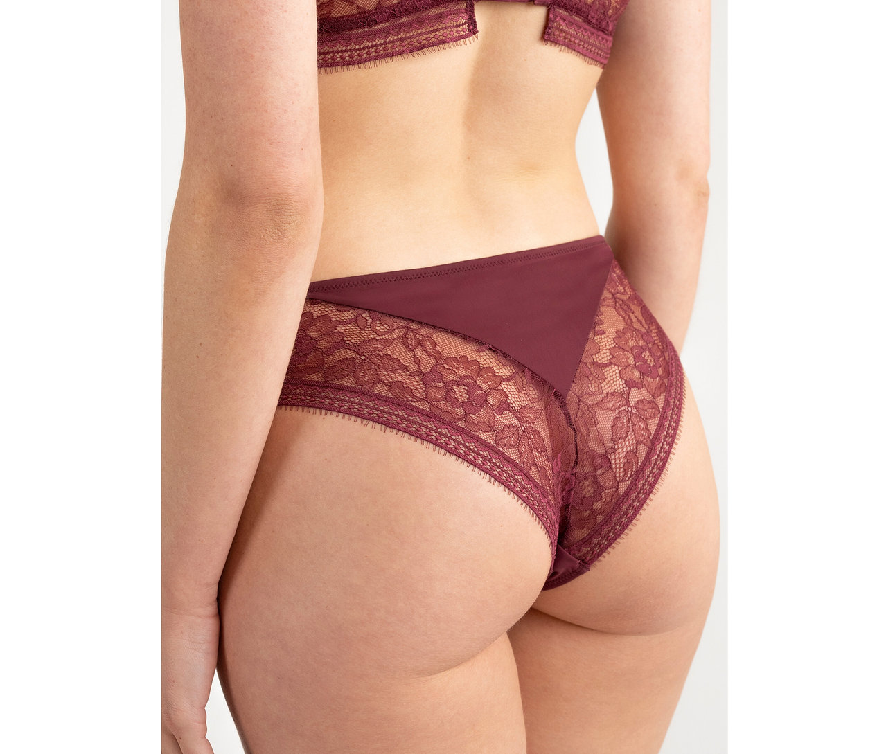 Rückenansicht einer Person, die einen bordeauxfarbenen Passionata Highwaist Slip »Jeanne« mit Spitzendetails trägt.