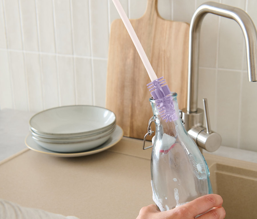 Eine Hand reinigt eine Flasche mit einer Flaschen-Reinigungsbürste.