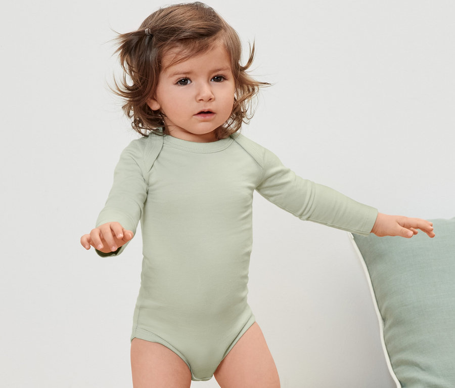 Kleinkind trägt einen grünen Langarmbody.