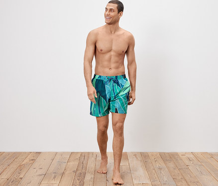 Mann trägt Badeshorts und geht.