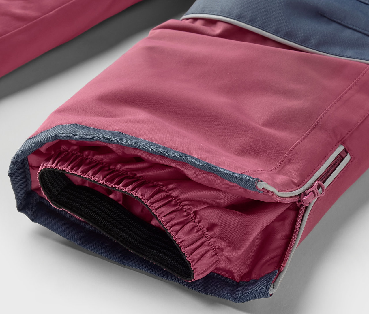 Detailansicht Hosenbein einer 2-teiligen Kinder-Schneekombi in Pink und Blau.