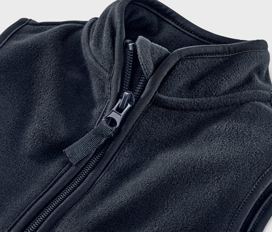 Detailaufnahme einer schwarzen Fleeceweste mit geöffnetem Reißverschluss.