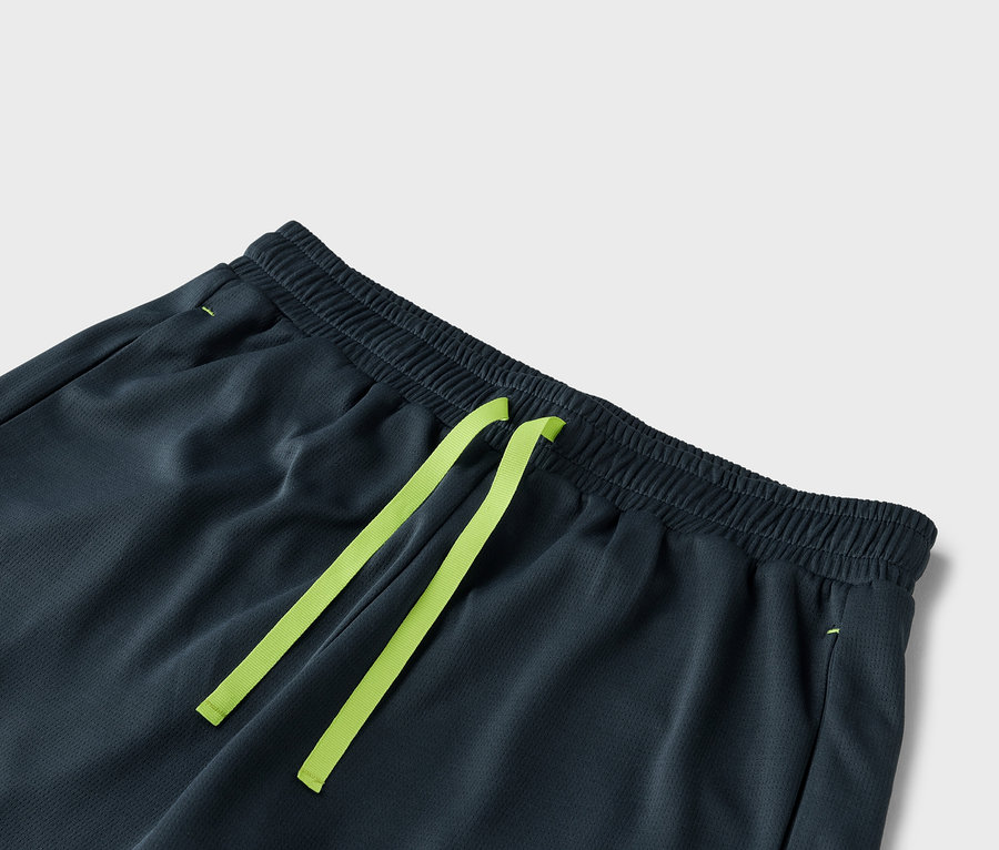 Nahaufnahme einer dunkelgrauen Shorts mit einem hellgrünen Kordelzug.