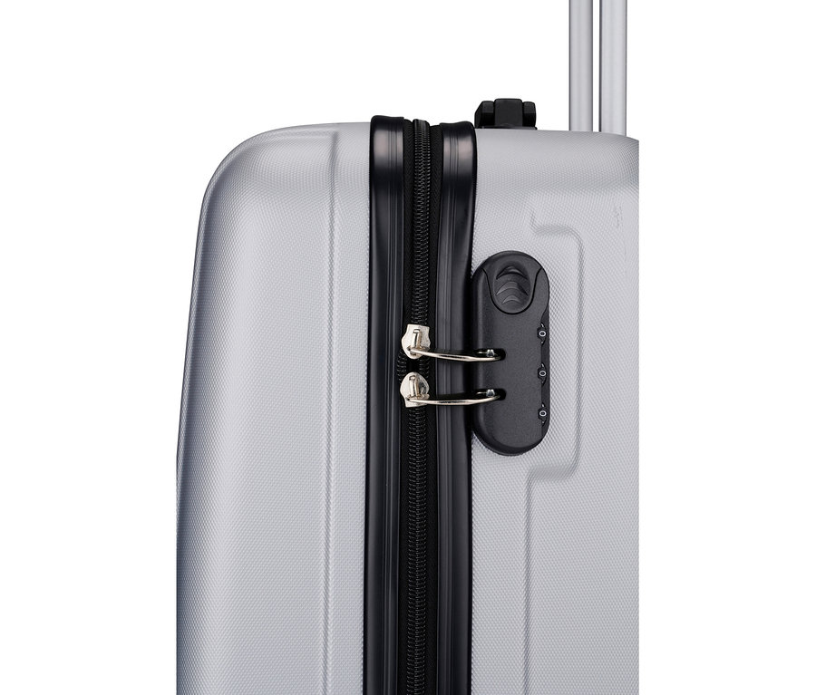 Nahaufnahme eines silbernen Koffers mit schwarzem Reißverschluss und Zahlenschloss.