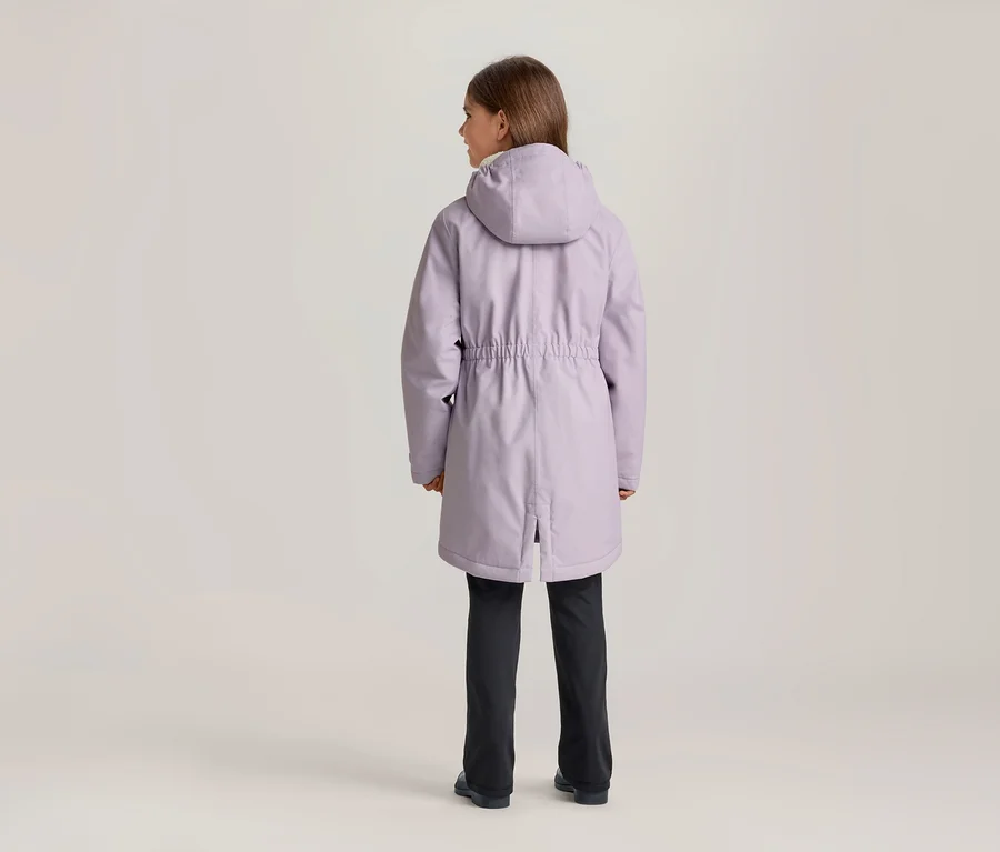 Eine junge Person steht mit dem Rücken zum Betrachter und trägt eine hellviolette Kapuzenjacke mit Kordelzug in der Taille und dunkle Hosen.