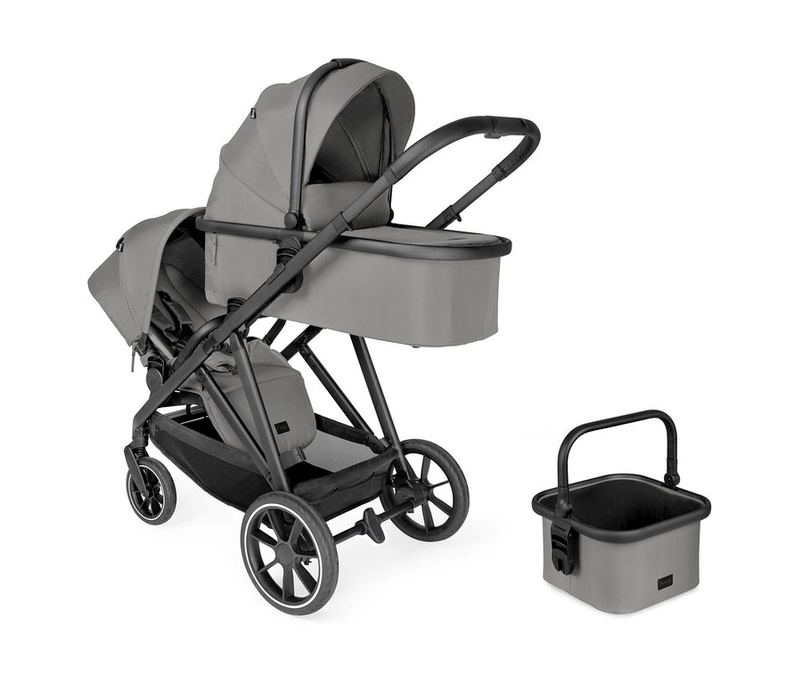 Grauer Zwillingskinderwagen mit Babywanne und Sportsitz, daneben ein passender grauer Korb mit schwarzem Griff.
