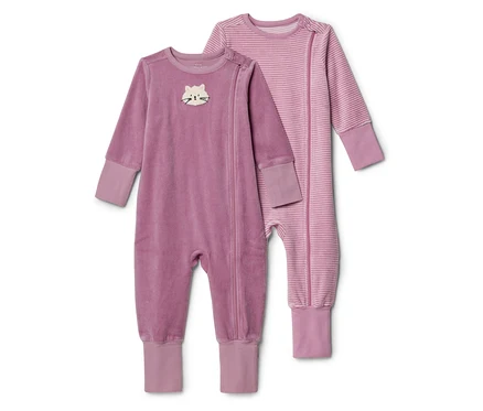 Zwei Baby-Strampler liegen nebeneinander. Links ein violetter Strampler aus weichem Stoff mit einer weißen Katzenstickerei auf der Brust und einem Reißverschluss. Rechts ein gestreifter violetter Strampler mit dünnen horizontalen Streifen und einem Reißverschluss. Beide haben Bündchen in einem helleren Violett.