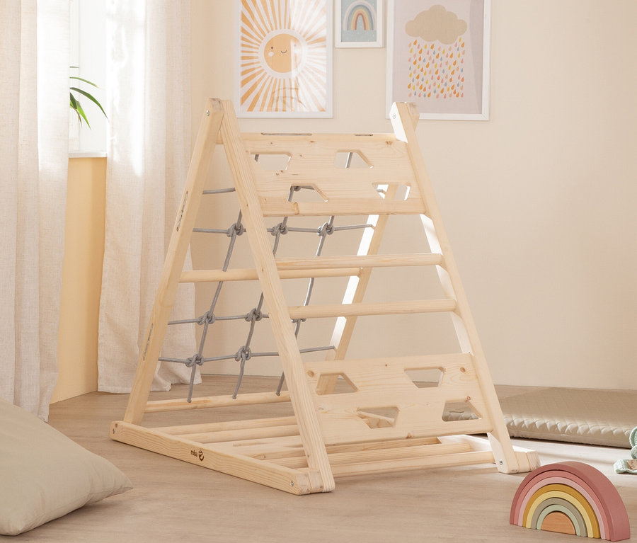 Ein roba Kletterdreieck aus Holz mit Kletternetz steht in einem Kinderzimmer.