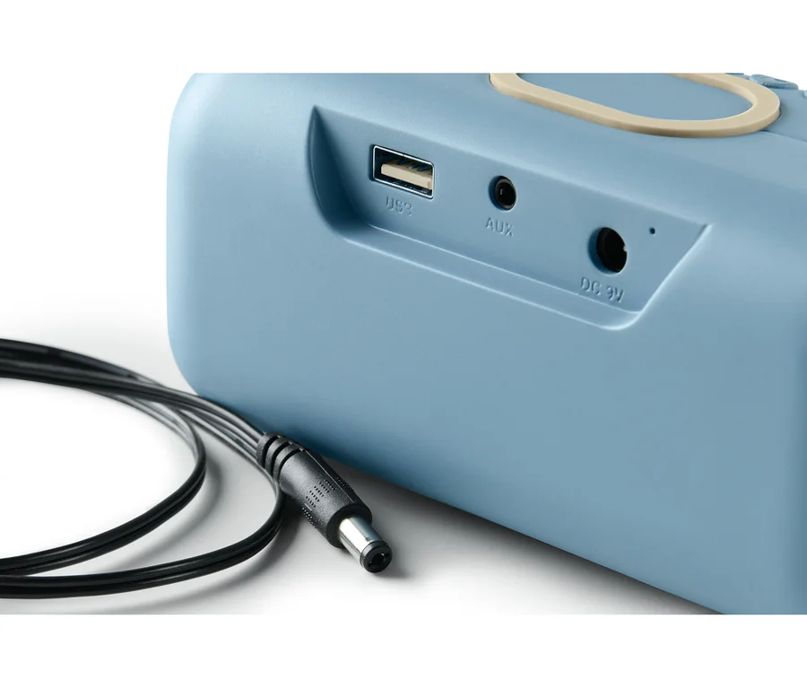 Detailansicht eines blauen Lautsprechers mit Qi-Charging und Kabel.