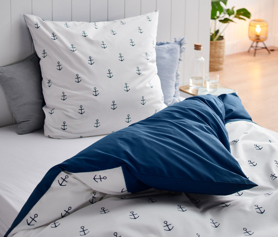 Renforcé-Bettwäsche in Normalgröße mit Ankermotiv auf einem Bett.