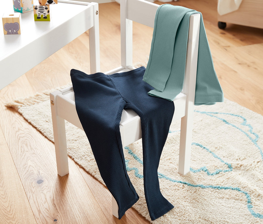 Zwei Rippleggings liegen auf einem weißen Stuhl.
