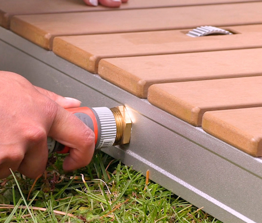 Person schließt Schlauch an Breuer®-Outdoor-Bodendusche »Fontana« an.