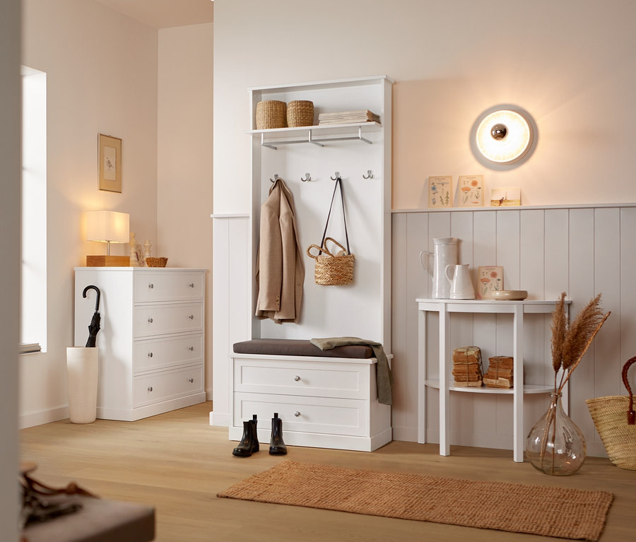 Flur mit Wand- und Deckenleuchte in Stuckoptik und Garderobe mit Sitzbank.