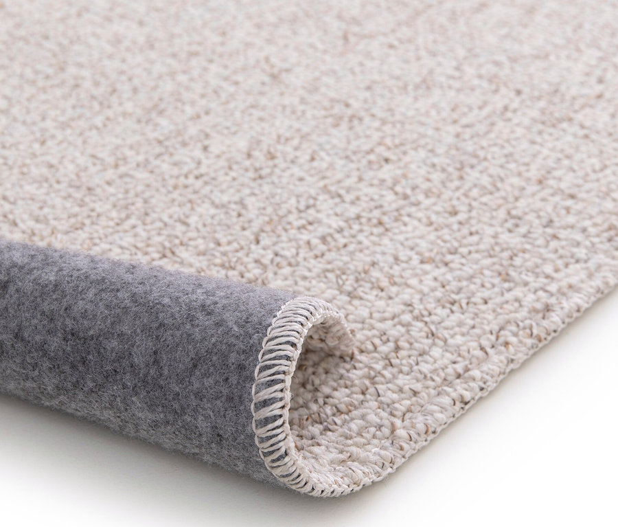 Detailansicht eines gerollten creme-anthrazitfarbenen Teppichs »Daisy«.