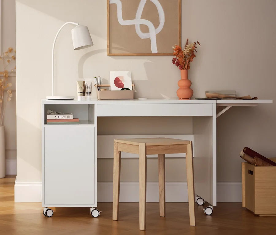 Innenraum mit einem dekorativen Regal aus Eschenholz, einem Multifunktionstisch mit erweiterbarer Tischplatte, einer LED-Akku-Tischleuchte und einem Hocker aus Eschenholz.