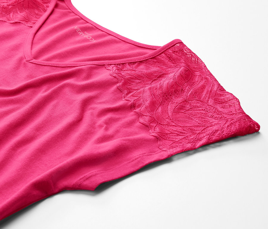 Detailaufnahme eines pinken Nachthemds mit Spitze auf weißem Hintergrund.