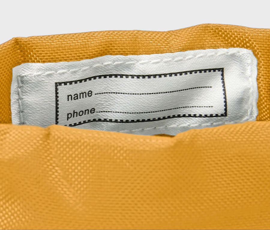 Detailaufnahme von gelben Kinder-Gummistiefeln mit weißem Namensschild.