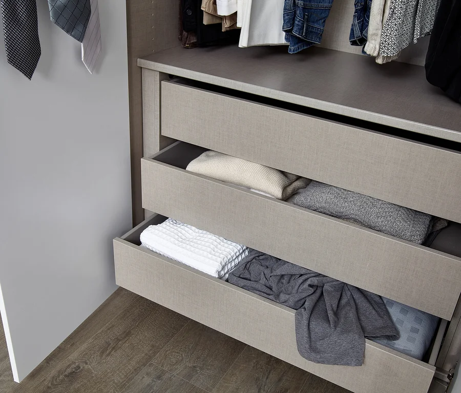 Ansicht von offenen Schubladen in einem Kleiderschrank mit gefalteter Kleidung.