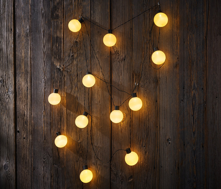 Zwei LED-Outdoor-Lichterketten hängen an einer Holzwand.